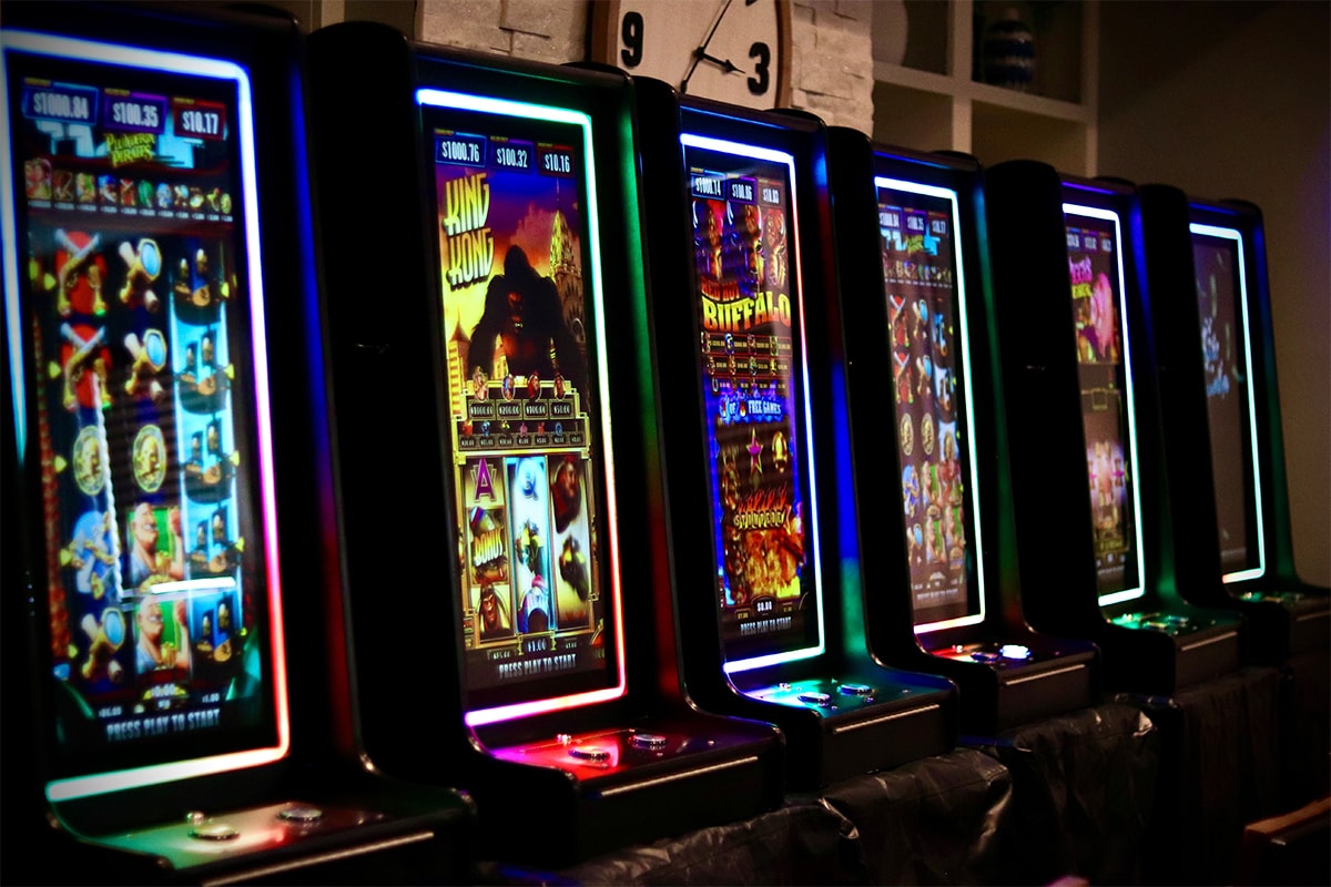 Row of neon-lit slot machines at an Austin Casino Party USA event