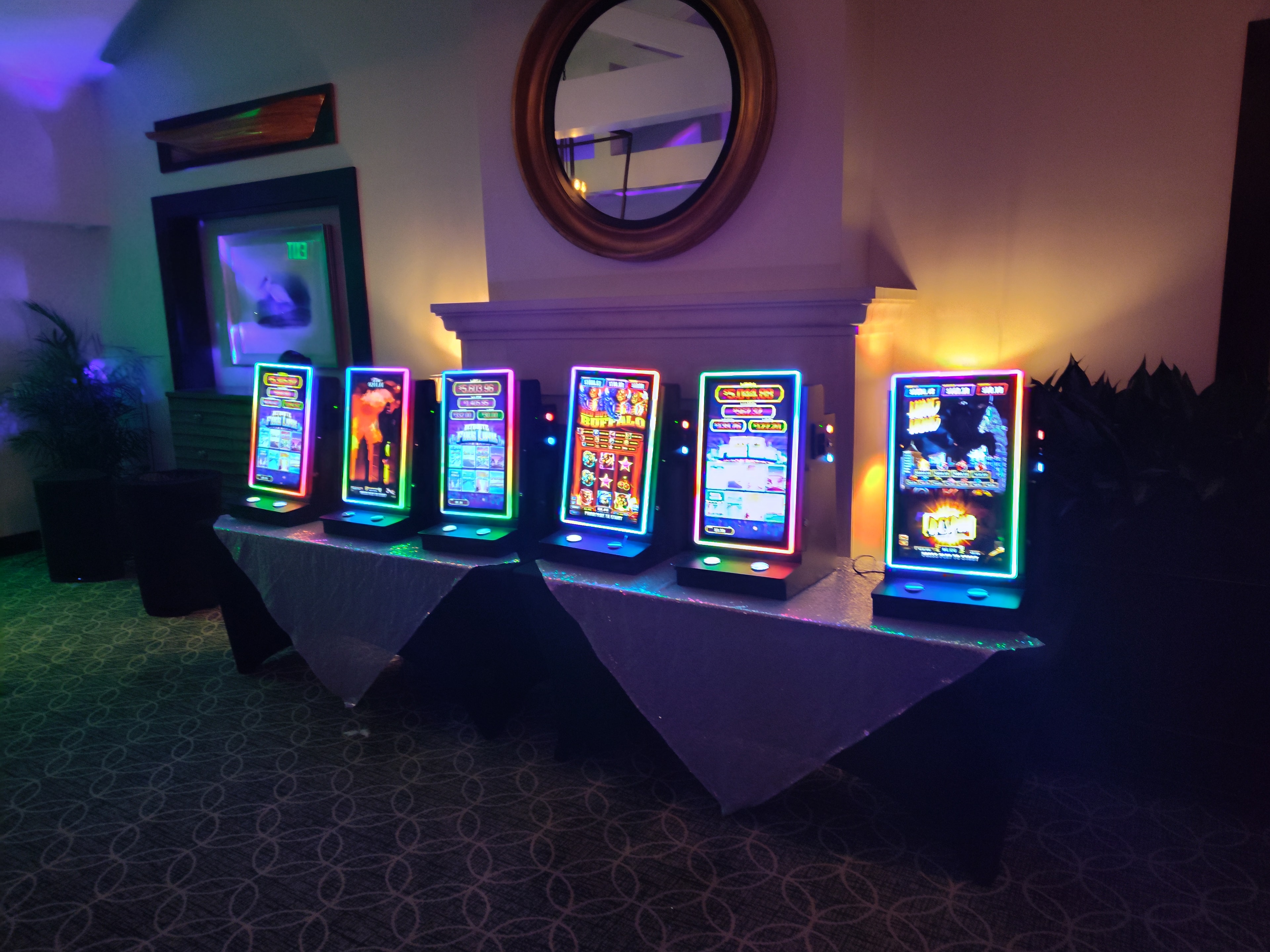 Neon-lit electronic slot machines displayed at a Casino Party USA event