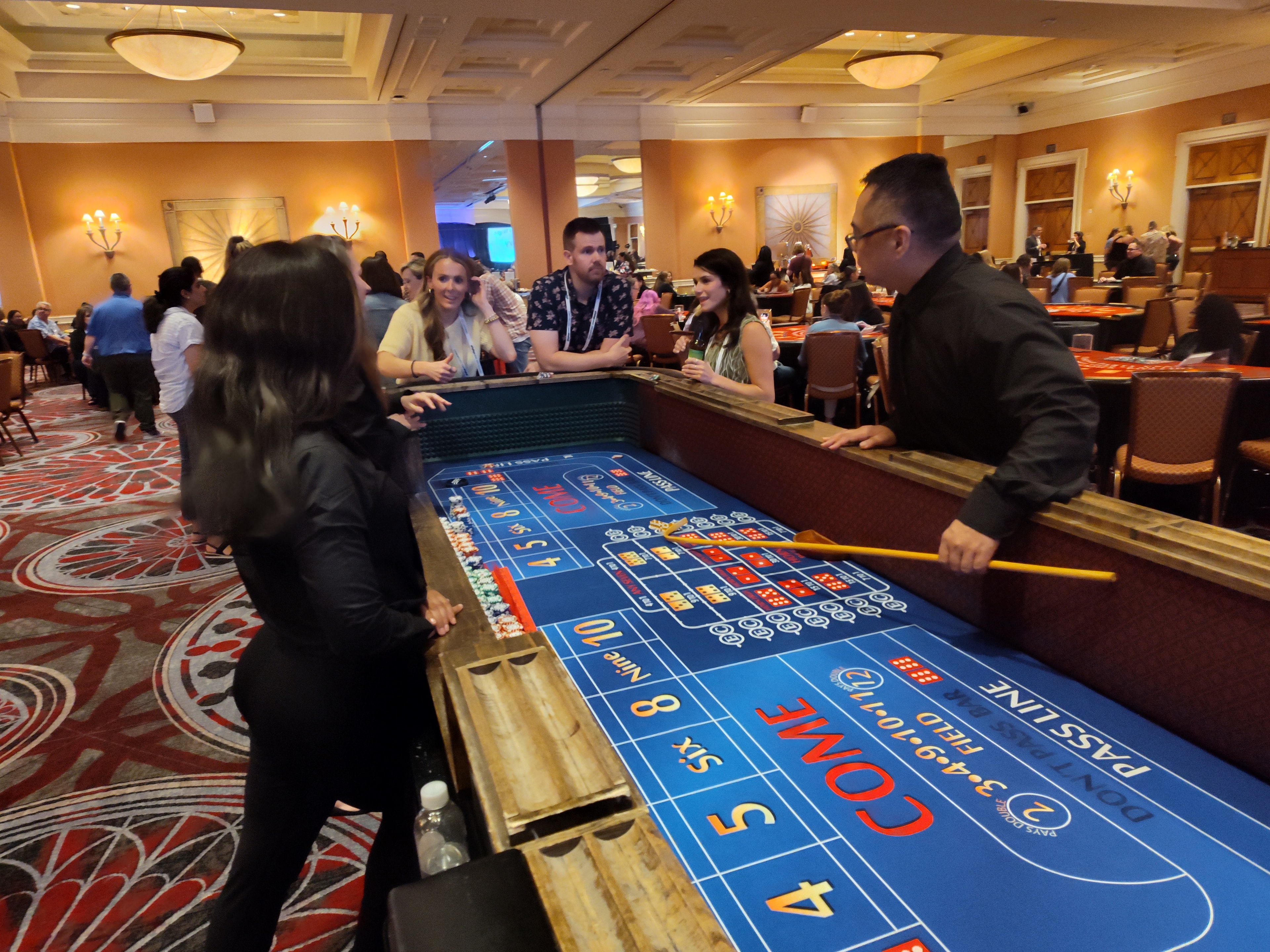 Guests at a Casino Party USA craps table in a large ballroom in Colorado Springs