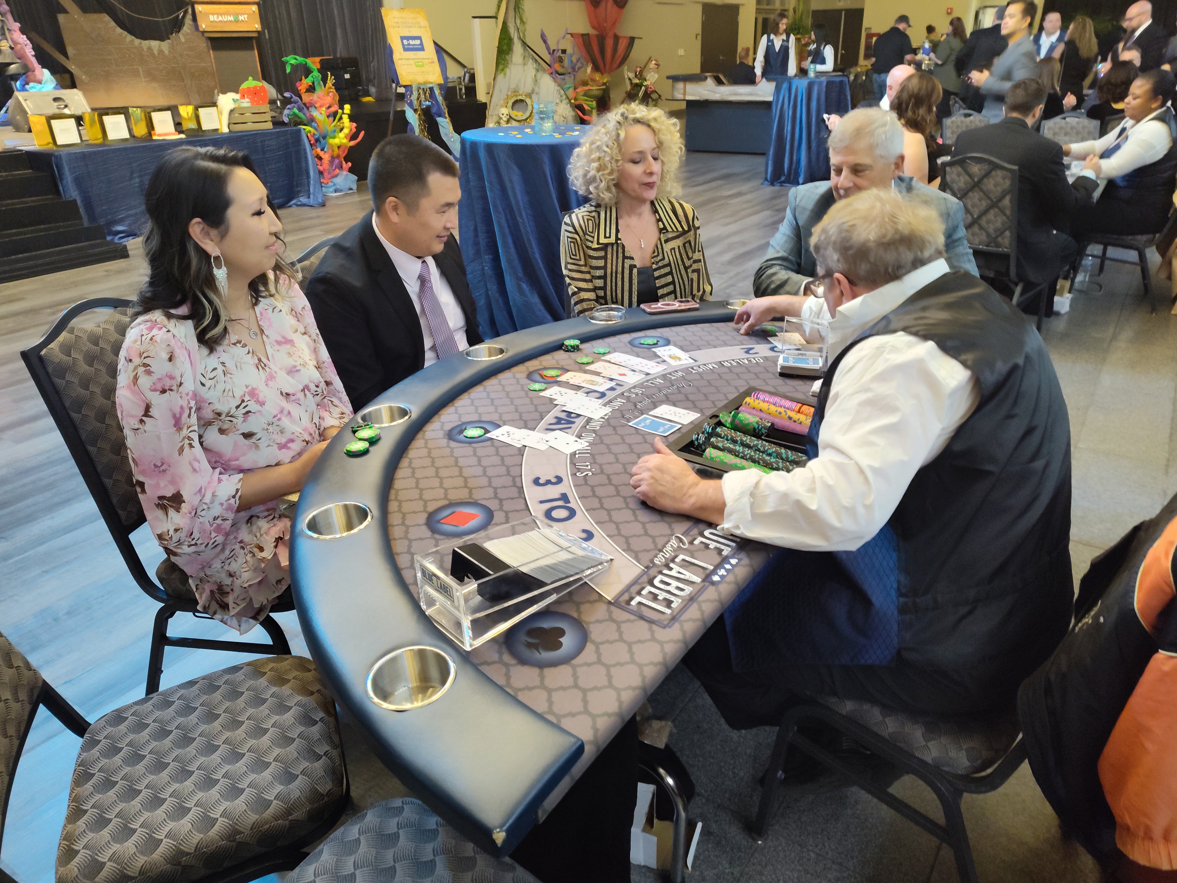Guests playing blackjack at a Blue Label Casinos table at a Houston casino fundraiser event