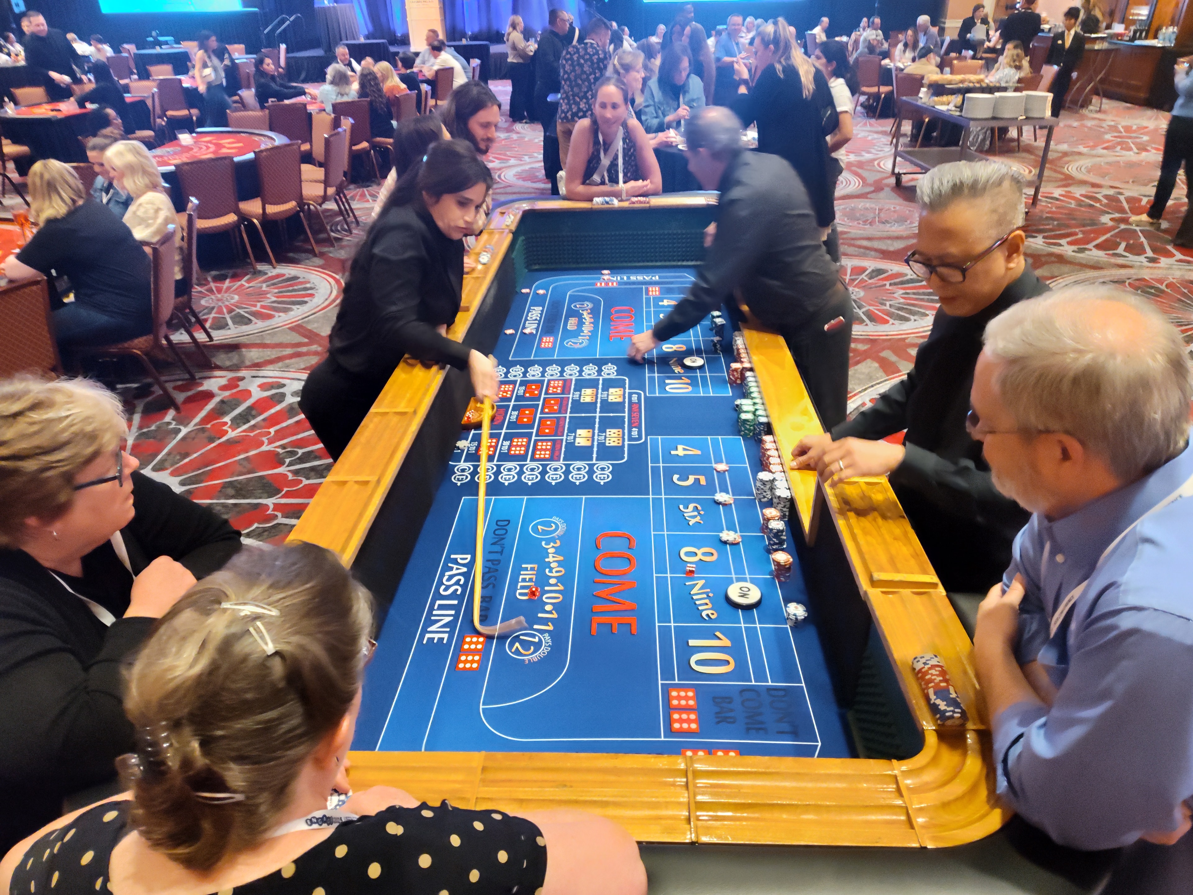 Dealers running a blue craps table with a packed crowd at a Las Vegas Casino Party USA event