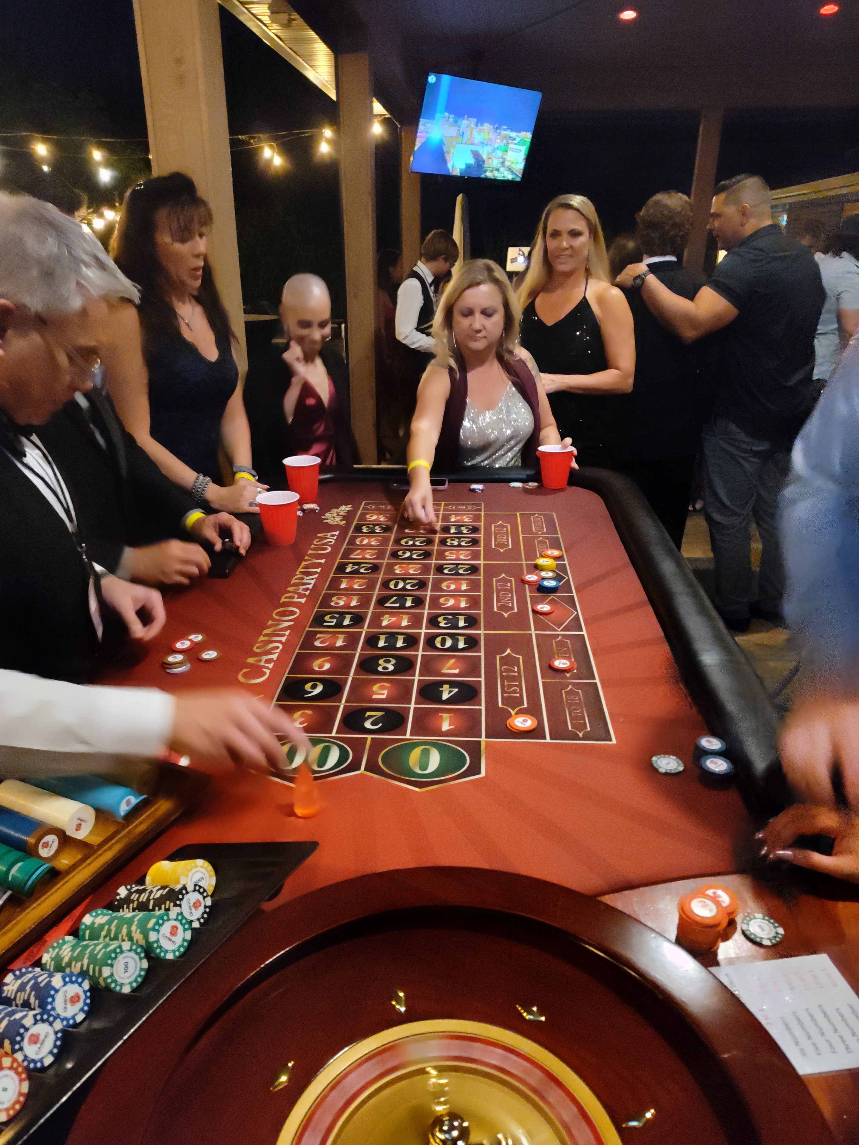 Guests placing bets at a Casino Party USA roulette table at an Omaha event