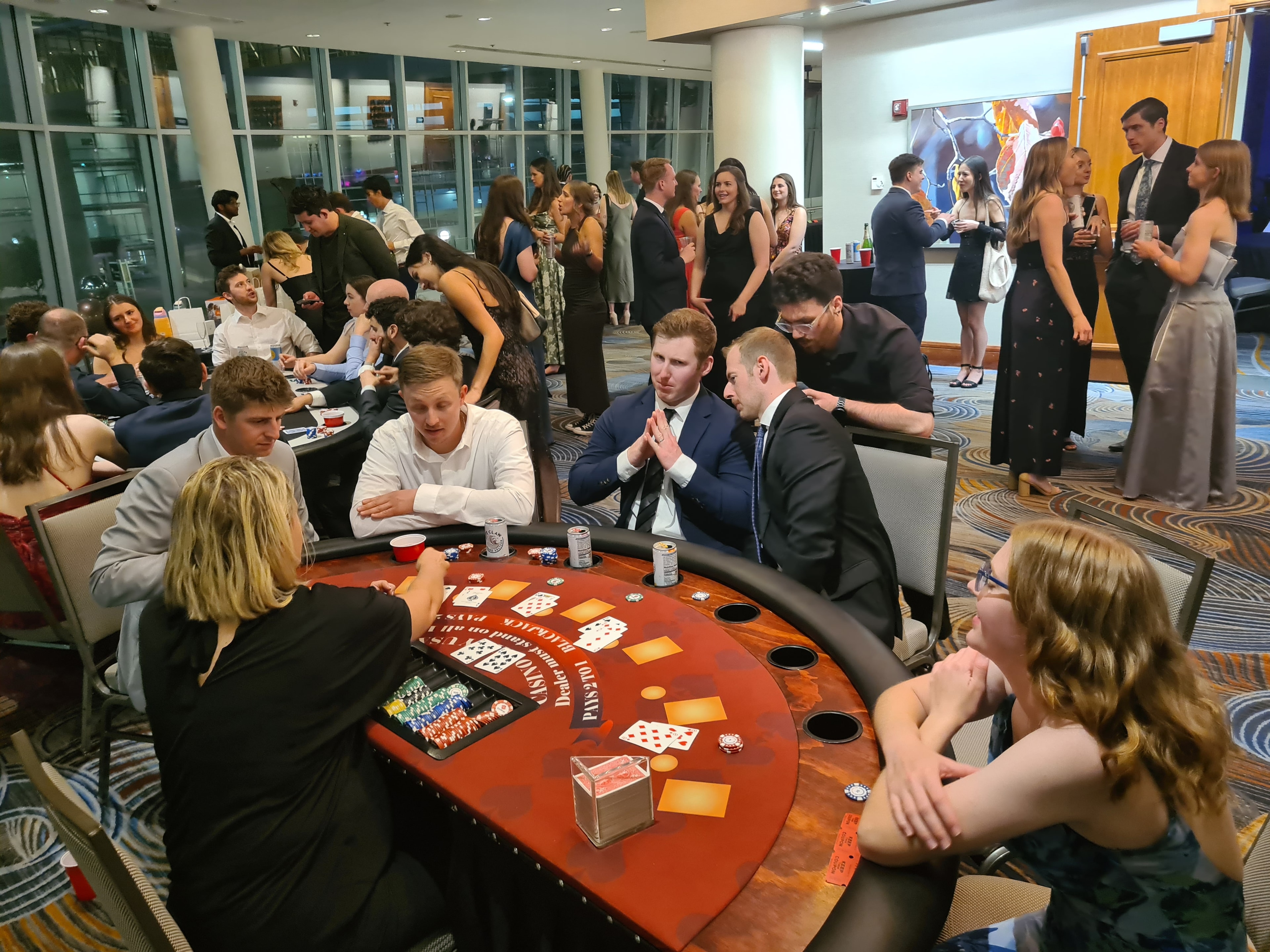 Wide-angle view of guests at blackjack tables in a large ballroom at an Omaha Casino Party USA event
