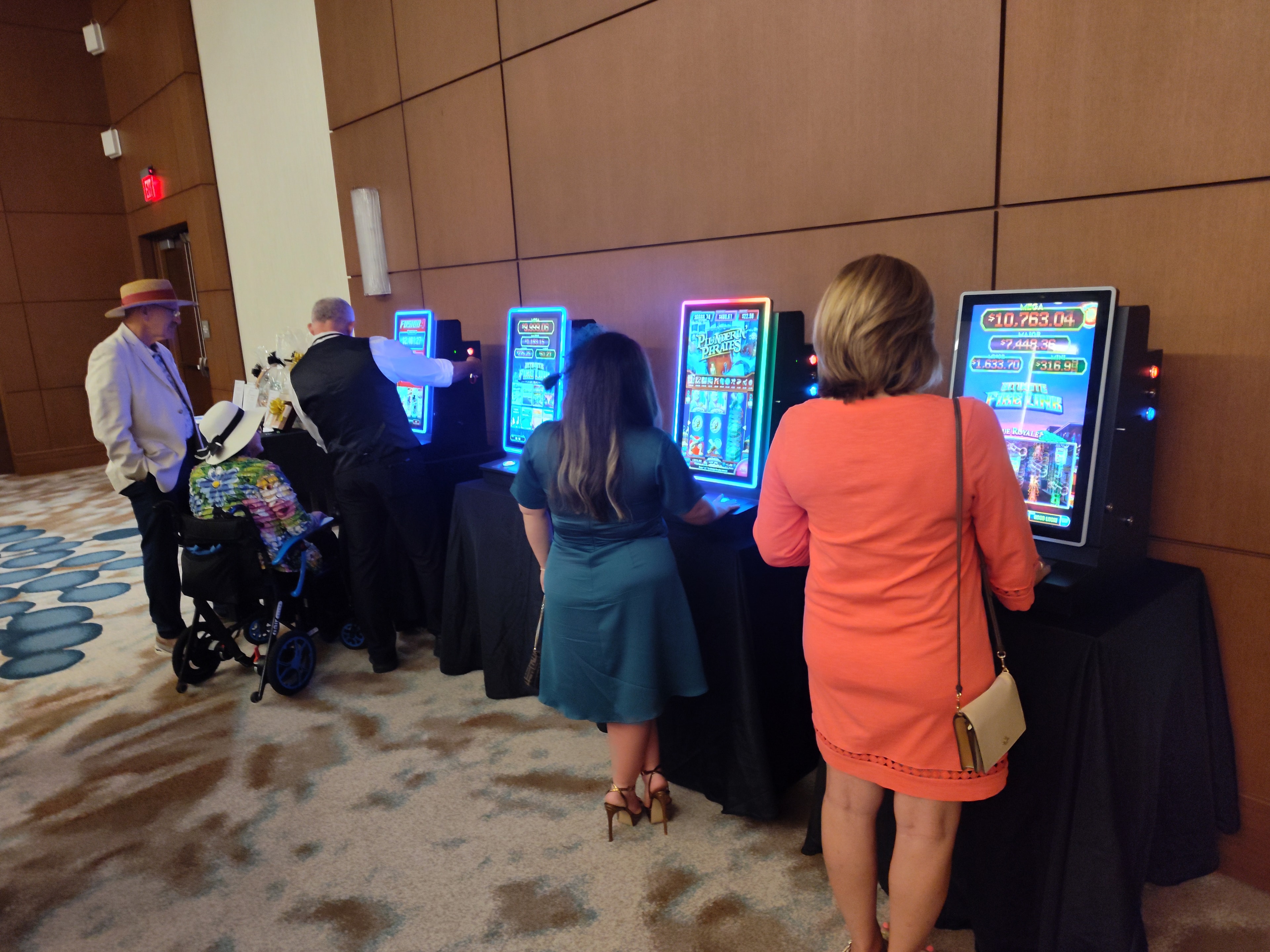 Guests playing slot machines along the wall at an Orlando Casino Party USA event