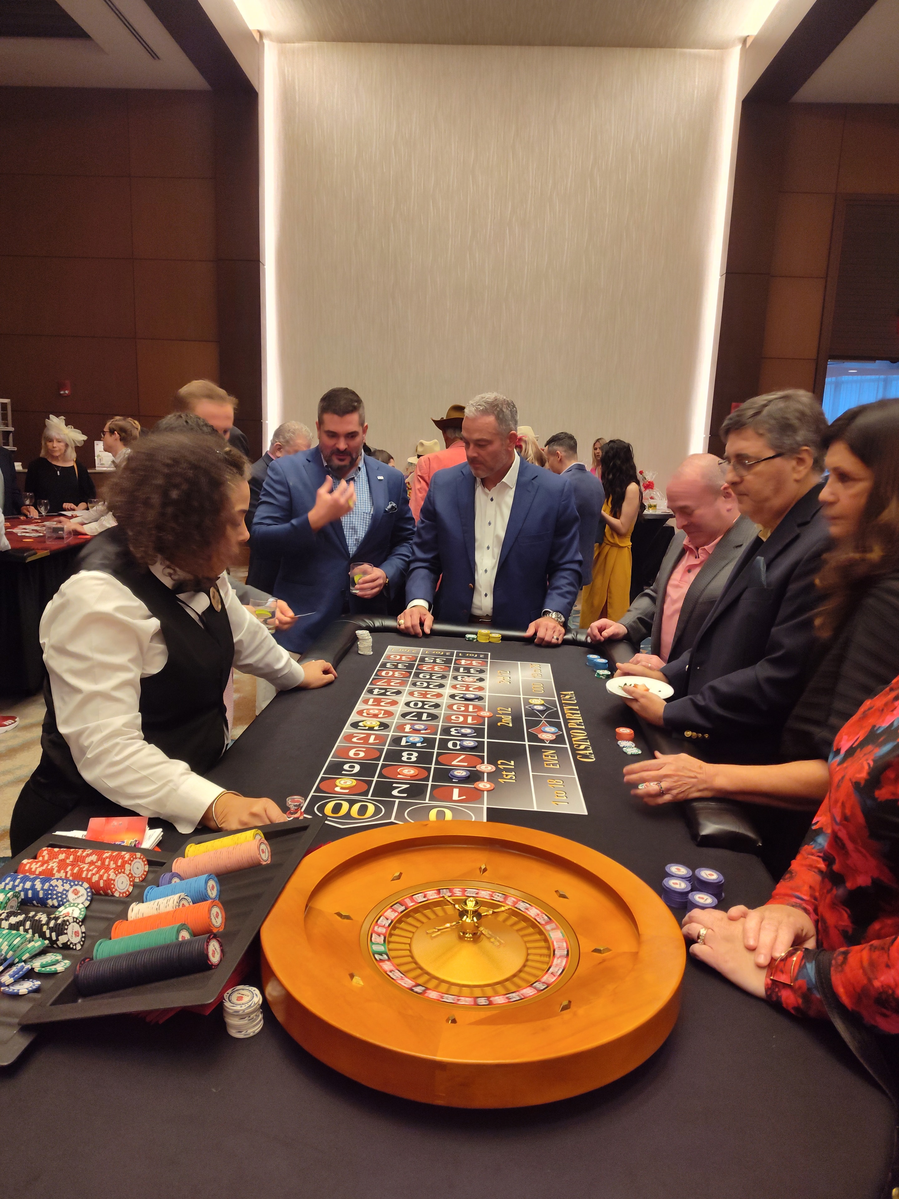 Guests packed around a Casino Party USA roulette table at an Orlando event