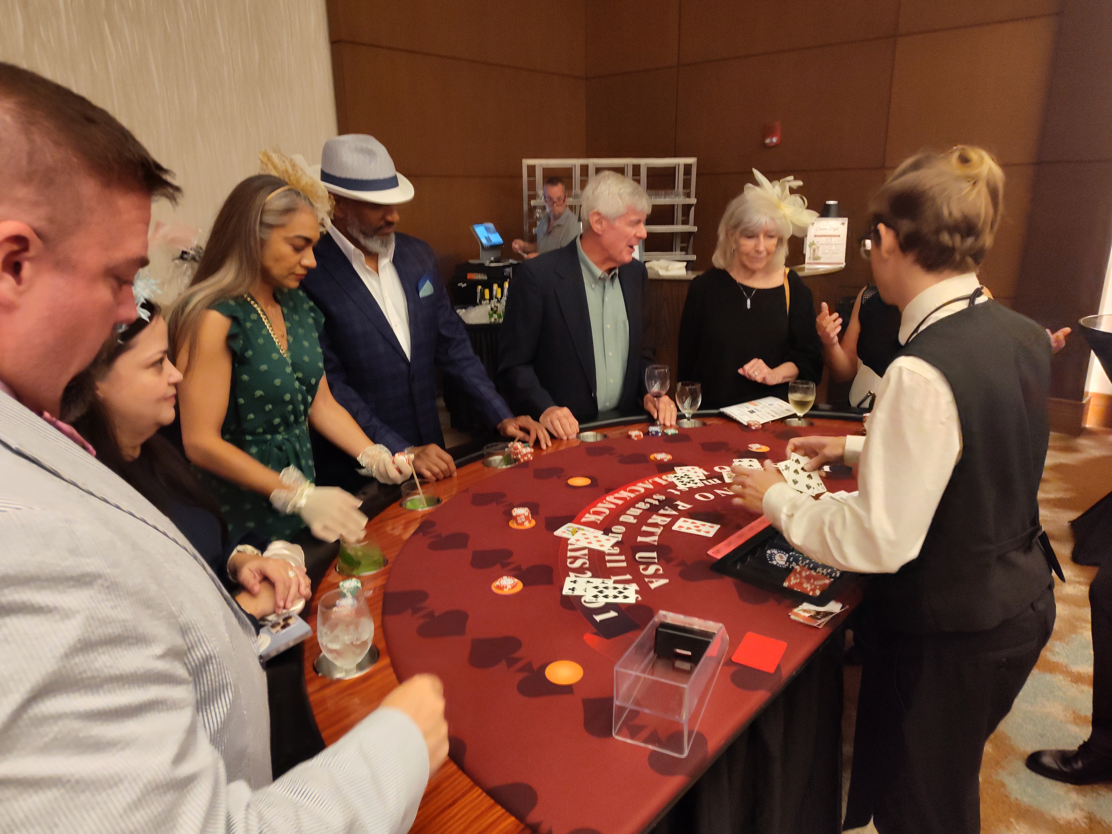 Guests in festive hats playing blackjack at a Casino Party USA branded table in Orlando