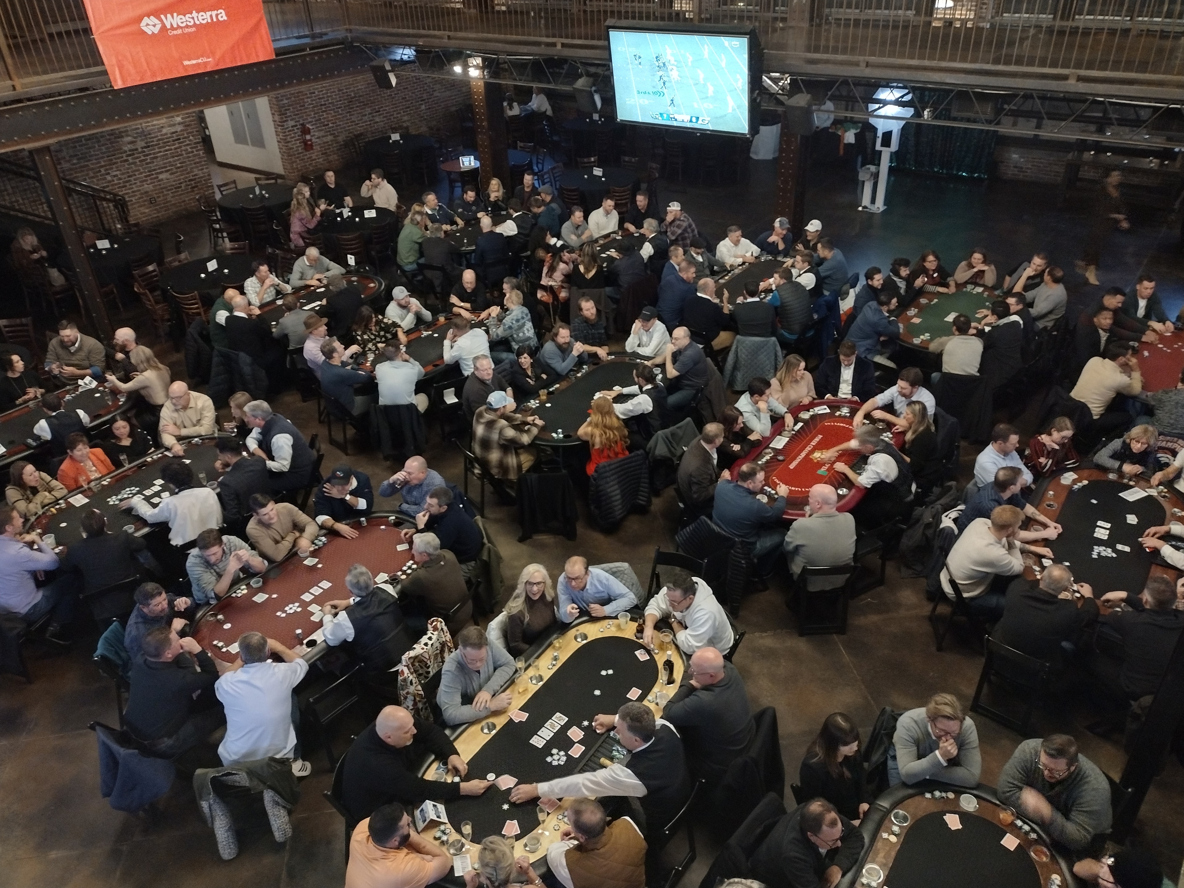 Aerial view of a massive Casino Party USA poker tournament with dozens of tables packed with players