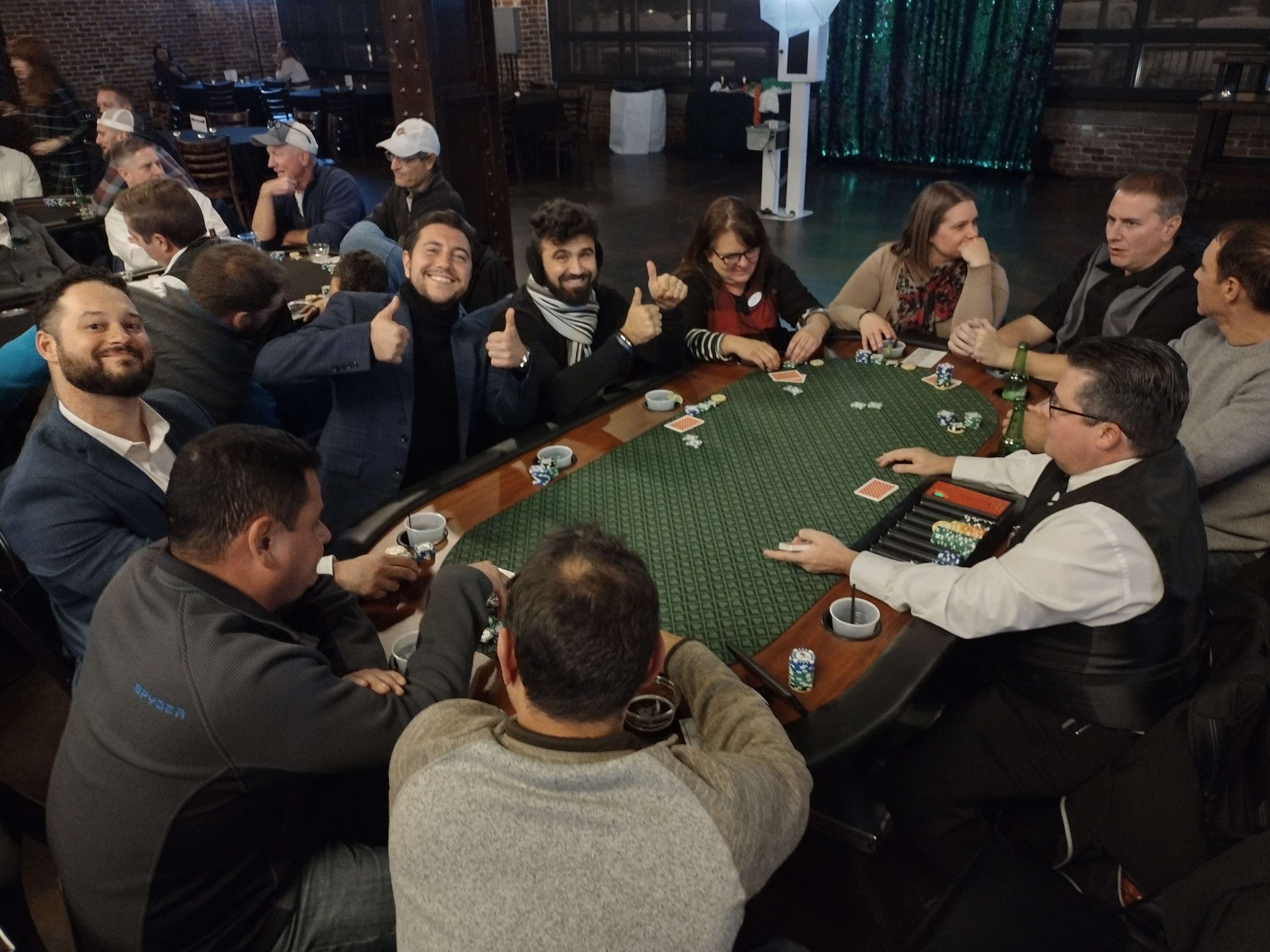 Guests giving thumbs up at a Casino Party USA poker tournament table