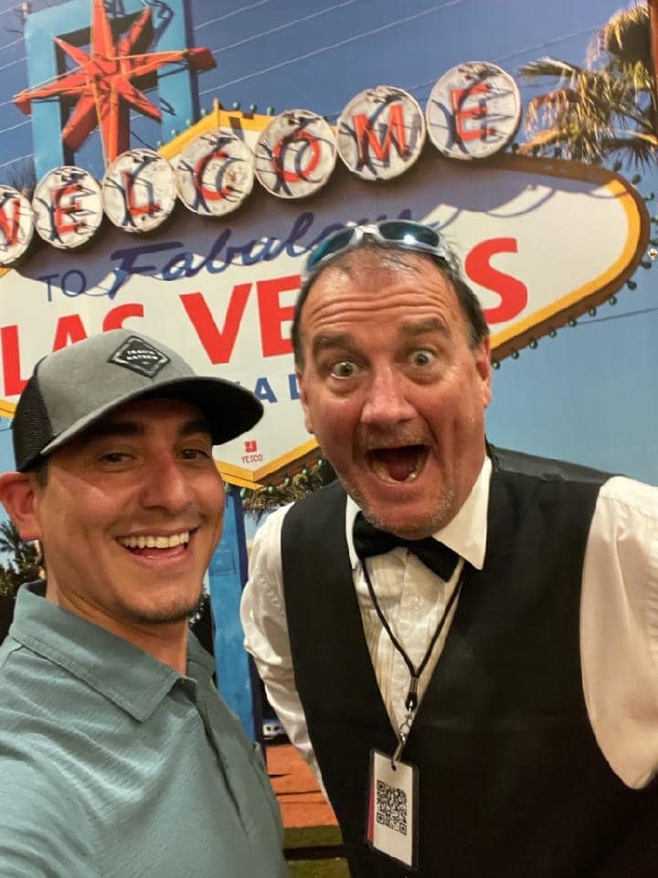 Guest and Casino Party USA dealer taking a selfie in front of the Welcome to Fabulous Las Vegas backdrop
